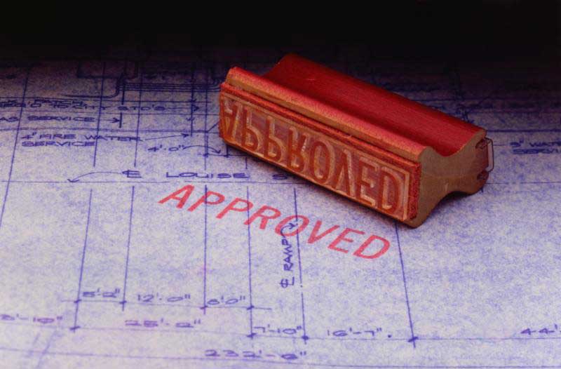 A stamp on top of a piece of paper with "Approved" written on it.