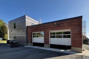Back of fire station with two apparatus bay doors open.