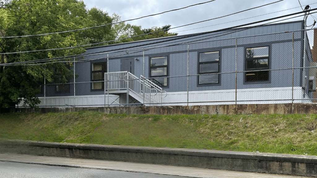 Exterior view of a triumph modular building showcasing a temporary modular construction design with a staircase and large windows.