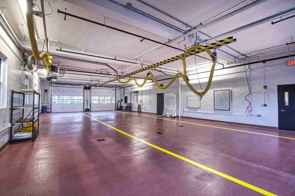 Interior view of a permanent modular building featuring spacious, open layout with overhead equipment and safety markings, ideal for modular construction projects.
