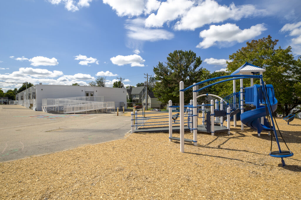 Exterior shot of Manchester Public School with blue playground structure in the forefront