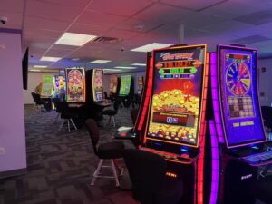 Interior photo of a modular casino that shows slot machines and chairs