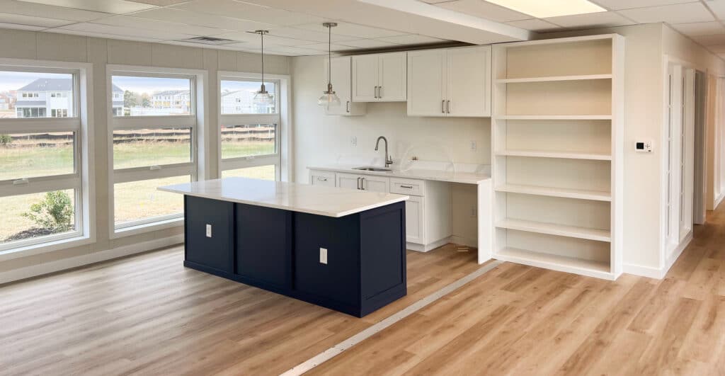 a kitchen with hardwood floors within a temporary modular housing unit.